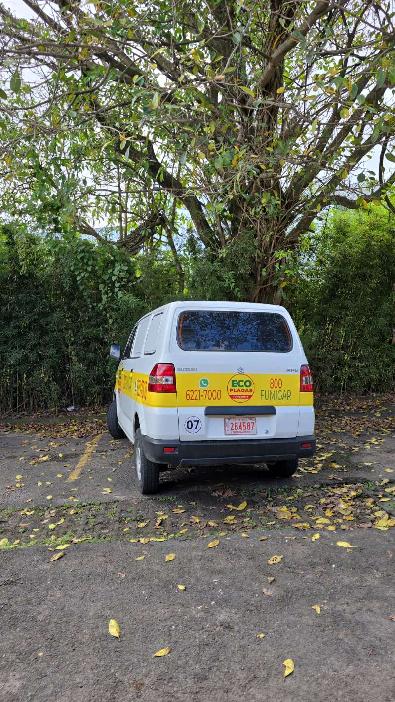 Furgón rotulado de EcoPlagas 800-FUMIGAR estacionado en un sitio de trabajo